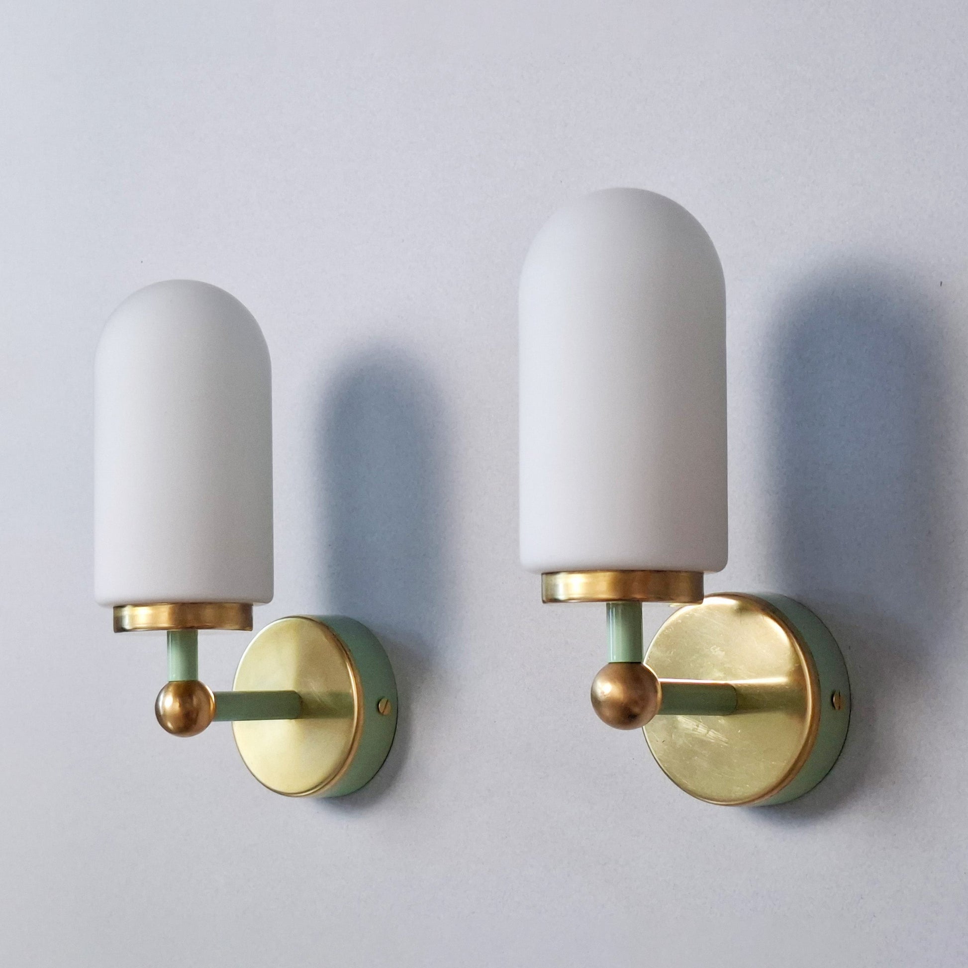 This is a pair of 1980s brass sconces with mint green accents and white frosted opaline shades - Retro Lamp Shop -