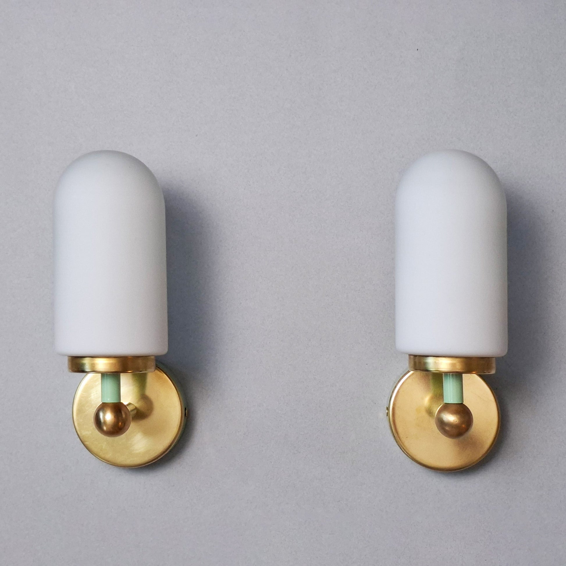 This is a pair of 1980s brass sconces with mint green accents and white frosted opaline shades - Retro Lamp Shop -